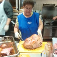<p>Volunteer Maria Vega slices up barbecue pork before a busy lunch at Caritas of Port Chester.</p>