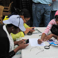 <p>Participants in the 2012 Urban Scavenger Race in Stamford sifting through clues.</p>