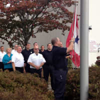 <p>Westport Firefighter Pete Nichio lowers the Blue Star Service Flag that flew outside fire headquarters while he was overseas.</p>