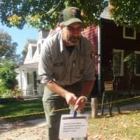 <p>Kevin Monthie, facility manager at Weir Farm National Historic Site, puts up the closed sign across the driveway in front of the visitor center. </p>