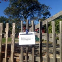 <p>A closed sign is attached to the Adirondack-style picket fence near the J. Alden Weir house. </p>