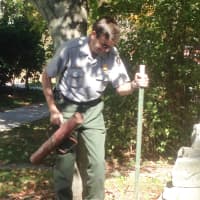 <p>A National Park Service employee pounds a sign post into the ground in preparation for closing Weir Farm on Tuesday. </p>