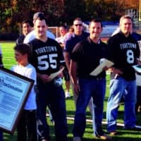 <p>Surrounded by former players, Ron Santavicca accepts a certificate declaring Saturday, Oct. 5 as Ron Santavicca Day in Westchester from County Executive Rob Astorino in a ceremony honoring the 1993-94 state title teams at halftime Saturday, Oct. 5.</p>