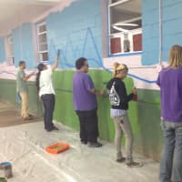 <p>Workers at Canine Kindergarten in Verplanck paint a mural for the pets.</p>