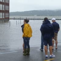 <p>Irvington residents look at flooding in the Bridge Street parking lot after Hurricane Irene caused the Hudson River to overflow on Oct. 28, 2012.</p>