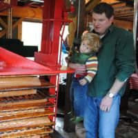 <p>The apple puree is put into blankets, to be pressed into juice. Cole Thompson, now 4, stands with dad, Ian Thompson, at his father&#x27;s cider mill.</p>