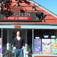 <p>Doug Kooluris stands outside his new wine and spirits store in Rye.</p>