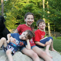 <p>Left to right: Guiding Eyes for the Blind stud dog Cosmo with Adam, Madelyn and Andrew Barti.</p>