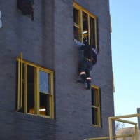 <p>Probationary firefighter demonstrates rappelling technique.</p>