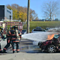 <p>Probationary firefighters extinguish a car fire during demonstration at the Westchester County Fire Training Center in Valhalla, N.Y.</p>