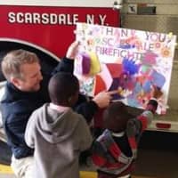 <p>The children of HELP Haven presented Scarsdale firefighter Patrick Gorham a thank you card to show their appreciation to him and his fellow firefighters.</p>