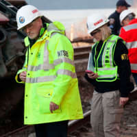 <p>NTSB investigator Michael Flanigon inspects track at the scene of the Metro-North train derailment in the Bronx on Sunday. </p>