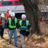 <p>NTSB officials retrieve an event recorder from the derailed Metro-North train in the Bronx.</p>