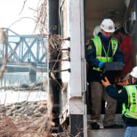 <p>NTSB officials retrieve an event recorder from a Metro-North train that derailed in the Bronx, N.Y.</p>