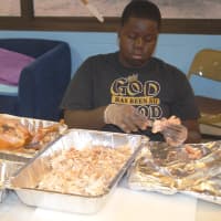 <p>A volunteer helps prepare a Thanksgiving feast at the Boys &amp; Girls Club of Stamford.</p>
