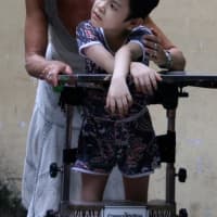 <p>Darien&#x27;s Lynn Gagliardi assists a child during her recent trip to an orphange in Vietnam.</p>