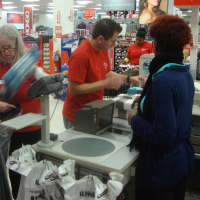 <p>Volunteers ring up items purchased and package them to be delivered to needy families.</p>