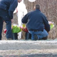 <p>Firefighters place more flowers as part of a memorial at the school sign. </p>