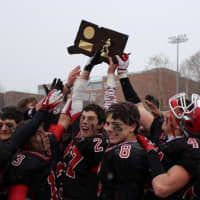 <p>New Canaan players celebrate after beating Darien on Saturday in the Class L football state championship game.</p>