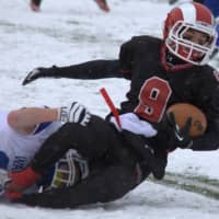 <p>New Canaan&#x27;s Cole Turpin hangs on to the football as he&#x27;s tackled by a Darien defender.</p>