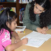 <p> Jenny Guaman (age 8), and Kimberly Rosario, a senior at Purchase College at the Port Chester-Rye Brook Public Library.</p>