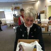 <p>Pat Romano of Stratford shows off what a finished box looks like before it gets closed up to be sent to the troops.</p>