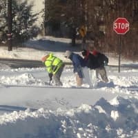 <p>It takes a whole crew to clear the snow on this Ridgefield sidewalk.</p>