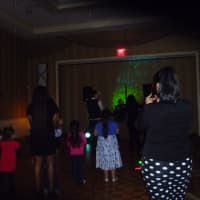 <p>Kids and their parents do the Cha Cha Slide at the Family Ties&#x27; annual holiday party.</p>