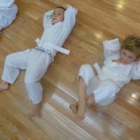 <p>Beginning martial artists work out with adult mentors at Kenshikai Karate in Hastings.</p>
