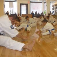 <p>Stretching before a Saturday mass workout at Kenshikai Karate in Hastings.</p>