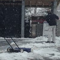<p>Mobil gas station employees shovel snow Monday afternoon. </p>