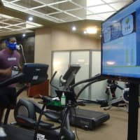 <p>A Life Time members runs on the treadmill attached to a computer that tells him his heart rate, speed and run time.</p>
