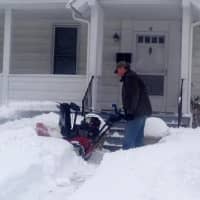 <p>A Danbury resident is thigh-high in snow as he clears a walkway on Thursday. </p>