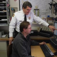 <p>Pound Ridge Police Chief David Ryan (standing) and Todd Baremore monitor power outages using new software. </p>