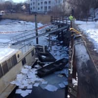 <p>A houseboat is sunken in the ice of the Norwalk River at the Oyster Bend Marina on Saturday. </p>