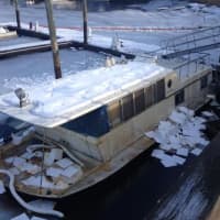 <p>A boom is placed around the sunken houseboat to contain the fuel spill in the Norwalk River. </p>