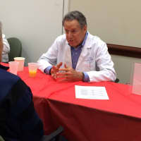 <p> A visitor chats with cardiologist Robert Stark, MD, at the Heart Health Fairs Meet the Cardiologist table.
 </p>