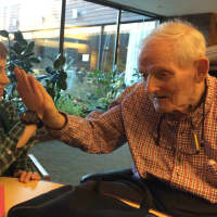 <p>Henry Benton, left, the youngest volunteer at the Waveny LifeCare Network in New Canaan, shares a high-five with Harvey Chandler.</p>