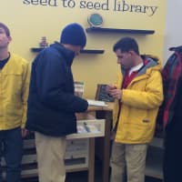 <p>Young adults from Ability Beyond put the envelopes they decorated into the  Seed to Seed Library at the Fairfield Wood&#x27;s Branch Library. </p>