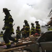 <p>Fire crews survey the wreckage of a building in Harlem that was destroyed in an explosion on Wednesday.</p>