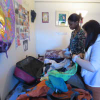 <p>College of New Rochelle students Marie Gomez and Raisa Jadotte make the final preparations before their trip.</p>