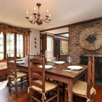 <p>The dining room with window seat and brick fireplace</p>