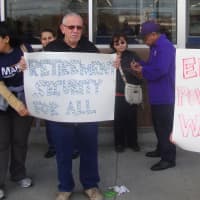 <p>Nelse Rodriguez and Maria Alicia Alcantara of SEIU 32BJ hold up signs to support the end to income inequality.</p>