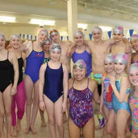 <p>Saw Mill Club&#x27;s swim team pose in remodeled swim cap for Aquatics Director&#x27;s honor. </p>