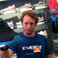 <p>Trevor Nelson, 24, of Fleet Feet Sports in Stamford holds a Nike shoe. He said it was difficult to talk about the Boston Marathon bombing after it happened.</p>