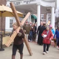 <p>Members of several Darien churches carry a large wooden cross through the downtown area to commemorate Good Friday.</p>