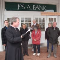 <p>The Rev. Christopher Leighton reads a prayer for artists outside the Darien Playhouse on Good Friday.</p>