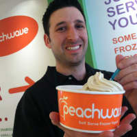 <p>Manager Ryan Ventura holds up a frozen yogurt at Peachwave, a new frozen yogurt business in New Canaan. It is located at 11 Forest St.</p>
