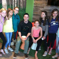 <p>Manager Ryan Ventura holds a frozen yogurt while surrounded by Saxe Middle School students Thursdayat Peachwave, a new frozen yogurt business in New Canaan. It is located at 11 Forest St.</p>