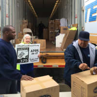<p>Workers from Meyer Van Lines helped the volunteers at the Fairfield 375 Food Drive put the full boxes of canned foods in the three trucks that the company donated. </p>